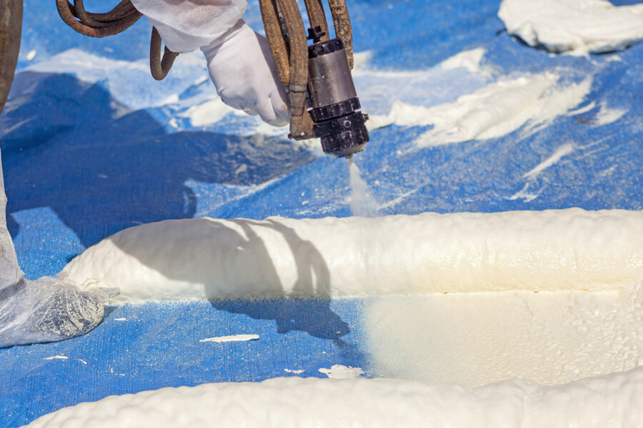 Spray Polyurethane Foam (SPF) roofing system being installed on a commercial roof