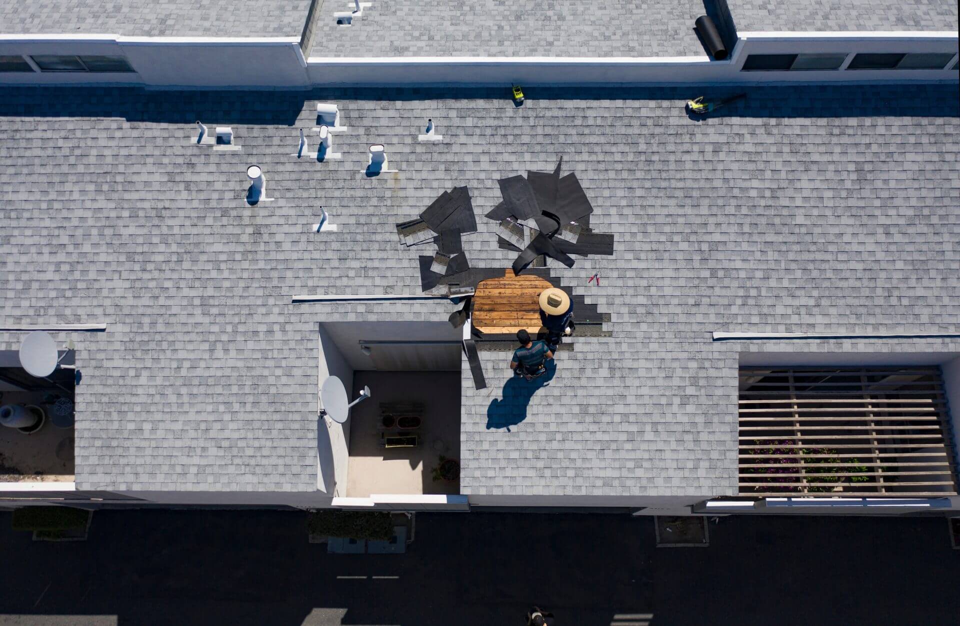 Licensed commercial roofers installing a new roof on a commercial building