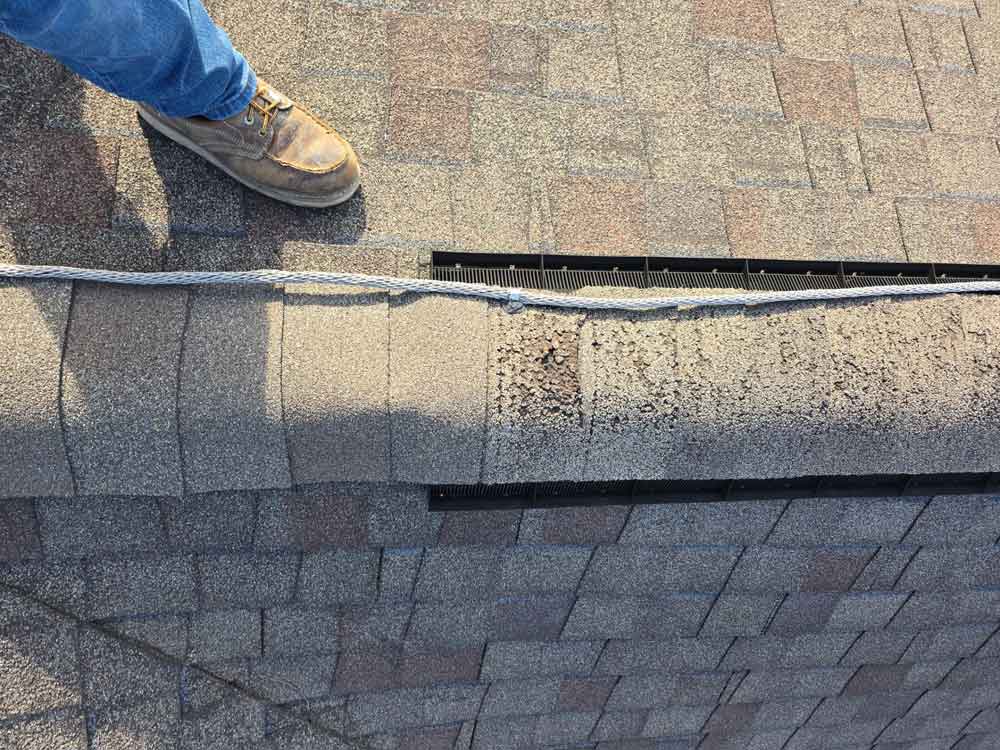 Aerial view of a damaged roof ridge that needs repair