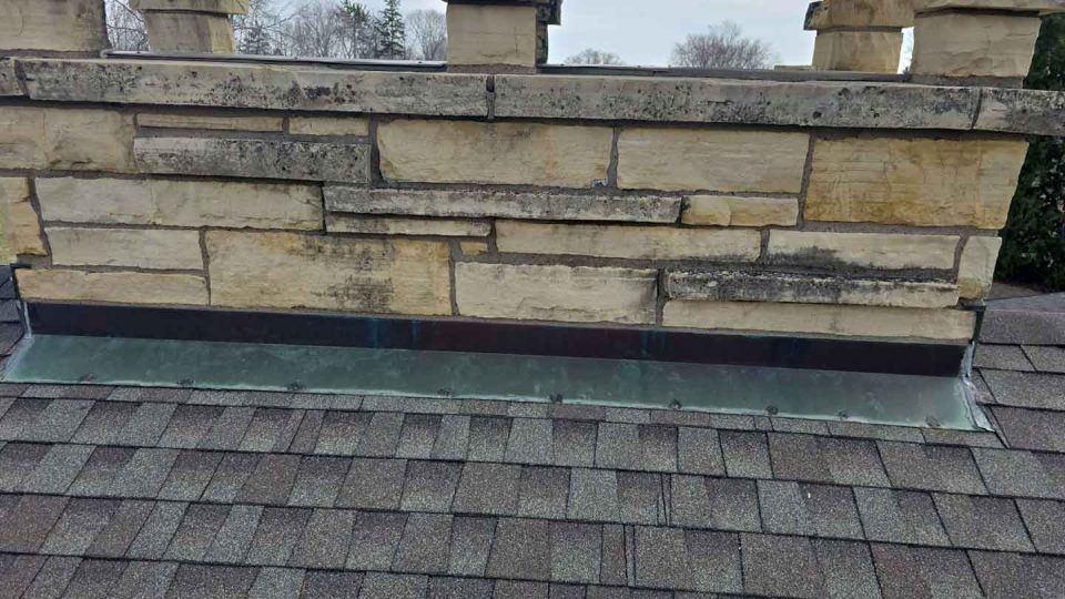 Dubuque, IA house #1 before roof replacement showing old flashing around chimney