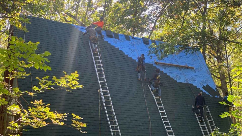 Elizabeth, IL house #3 during roof replacement with roofers on ladders installing new asphalt shingles