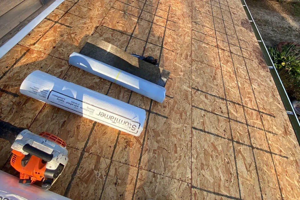 Photo taken by a roofer after tear down, showing plywood structure and materials for new roof install