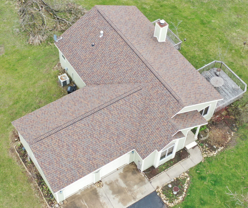 Aerial view of a home's new roof installation using brown asphalt shingles