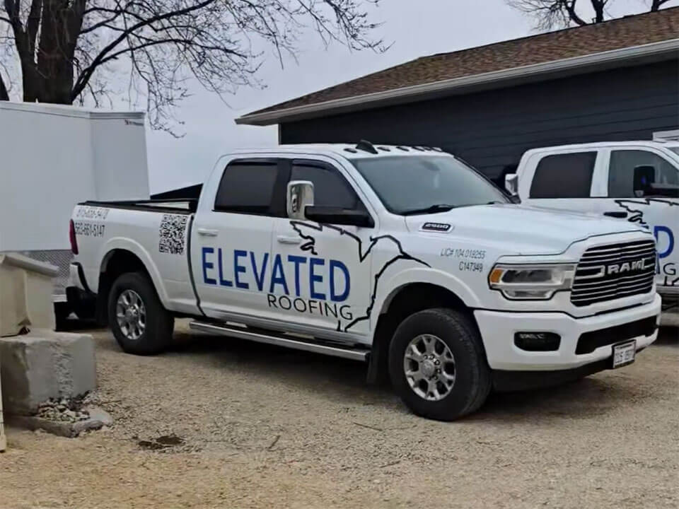 White pickup truck with the Elevated Roofing logo on the side covering front and rear doors